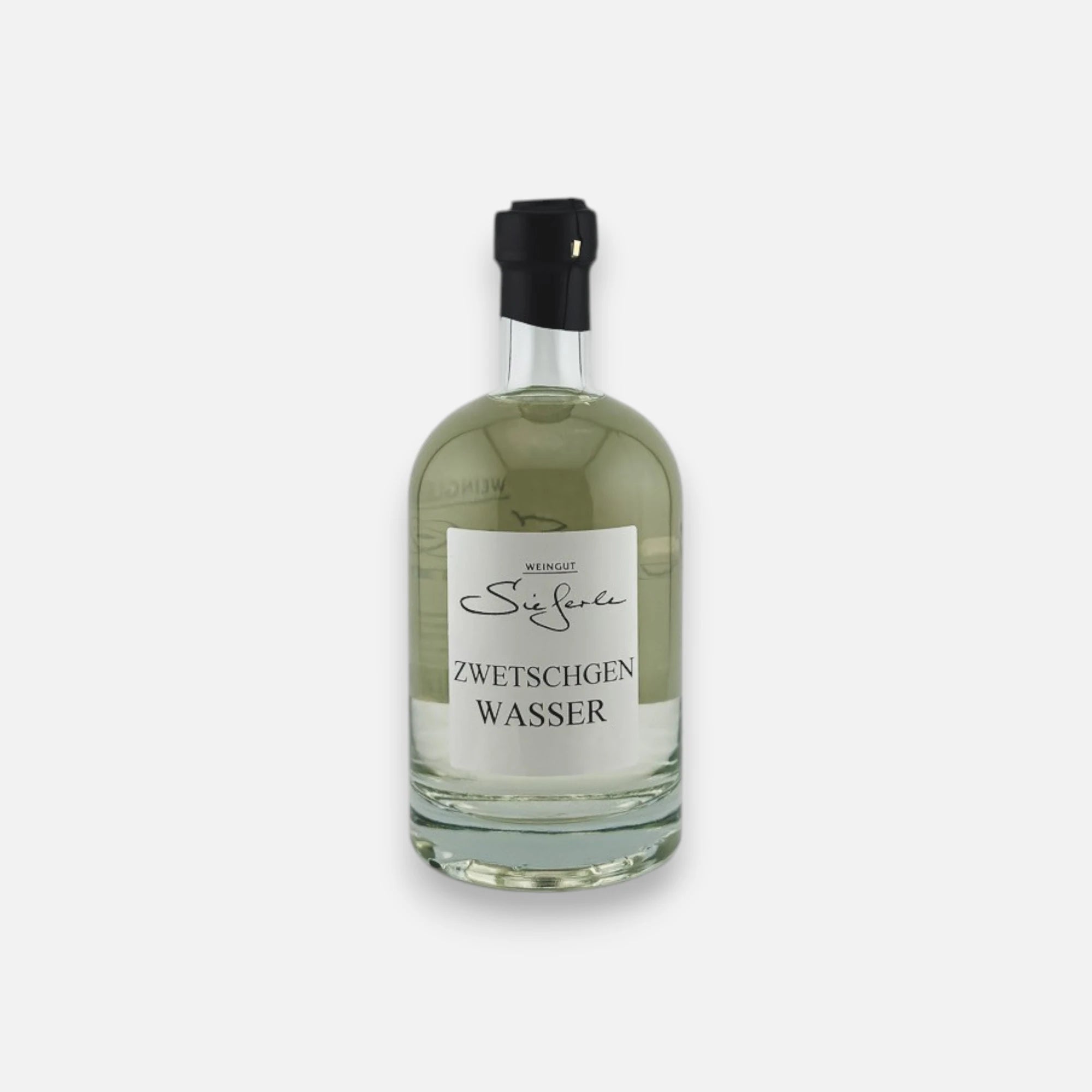 Weingut Sieferle Zwetschgenwasser in klarer Glasflasche mit schwarzem Verschluss und weißem Etikett vor neutralem Hintergrund.